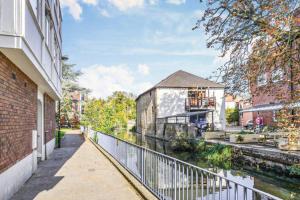 a walkway next to a building next to a river at Apartment in the heart of the city centre, live like a local in Oxford