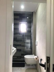 une salle de bain avec toilettes et une lumière au mur dans l'établissement Noah's Boutique - Apart-Hotel in Korce, à Korçë