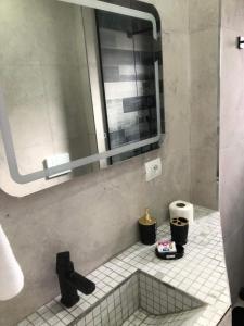 une salle de bain avec un miroir et un sol carrelé dans l'établissement Noah's Boutique - Apart-Hotel in Korce, à Korçë