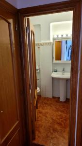 ein Badezimmer mit einem Waschbecken, einem WC und einem Spiegel in der Unterkunft appartement pied dans l eau in El Brosquil
