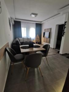 Una sala de estar con un sofá, una mesa y sillas. en Apartments Isidora, en Novi Sad 34 fotos más