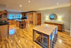 a kitchen with a wooden table and a wooden floor at Colleton Cottage at Lovelady Shield- With Hot Tub in Alston