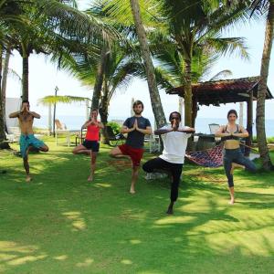 a group of people doing yoga on the beach at Ocean Breeze Villa in Galle