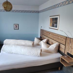 Schlafzimmer mit einem Bett mit weißer Bettwäsche und Kissen in der Unterkunft Gasthof Goldene Krone in Selbitz