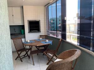 balcón con mesa y sillas en Residencial Atenas I, en Bombinhas