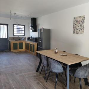 a kitchen with a wooden table and a refrigerator at Les Villas RIO Saint André in Saint-André