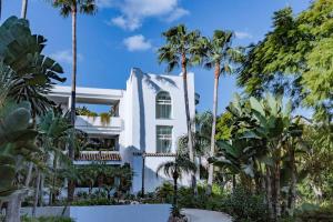 a white house with palm trees in front of it at Molo Bahia Apartment Near the beach in Marbella
