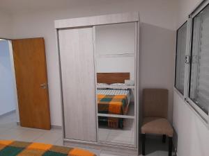 a bedroom with a closet with a bed and a chair at Departamento céntrico in Esperanza