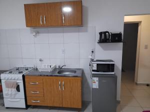 a small kitchen with a sink and a microwave at Departamento céntrico in Esperanza