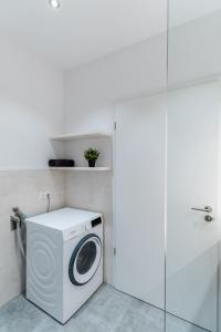 uma máquina de lavar roupa numa casa de banho ao lado de uma porta em Handmade I Modern I Luxury I Kitchen I Home Office I Netflix em Holzgerlingen