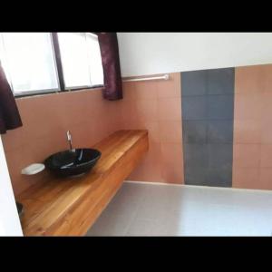 a bathroom with a black sink and a shower at Khum Charoen Homestay 
