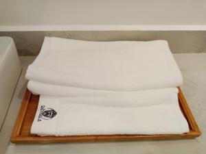 - une pile de serviettes blanches sur un plateau en bois dans l'établissement Bathala Resort, à Panglao