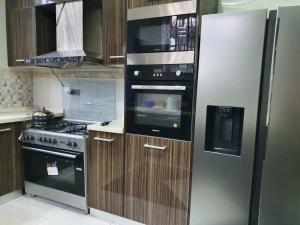 a kitchen with a refrigerator and a microwave at Villa Nelomoor in Kwabenya
