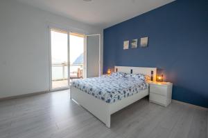 a blue bedroom with a bed and a large window at Happy Guest Apartments - Blue Apartment in Riva di Solto