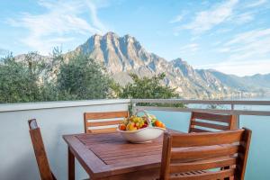 - une corbeille de fruits assise sur une table sur un balcon dans l'établissement Happy Guest Apartments - Blue Apartment, à Riva di Solto