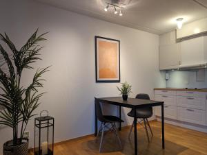 una cocina con mesa, sillas y una planta en Hotell Bro, en Kristinehamn