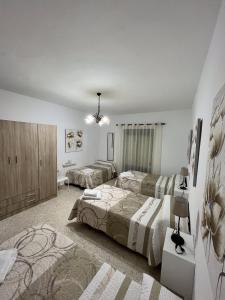 een slaapkamer met 2 bedden en een kroonluchter bij El Rincón de Matías (Apartamento turístico) in Segura de León