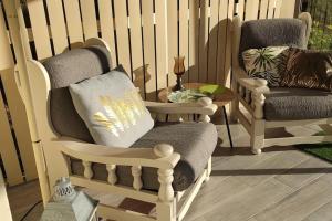 a porch with two rocking chairs and a table at Magnifique maison familiale située à MORLAIX in Morlaix