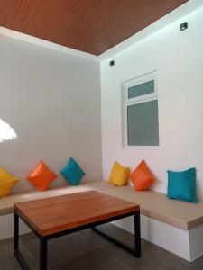 Habitación con banco y almohadas de colores. en Bathala Resort en Panglao City