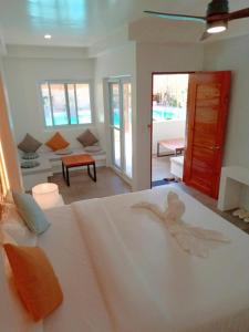 1 dormitorio con 1 cama blanca y sala de estar en Bathala Resort en Panglao City