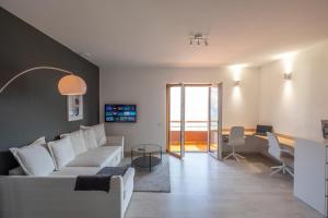 a living room with a white couch and a table at Happy Guest Apartments - Dolce Vista in Riva di Solto