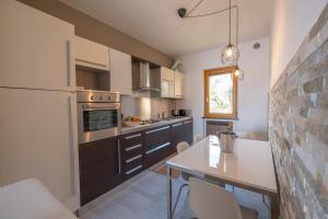 a kitchen with a white refrigerator and a table at Happy Guest Apartments - Dolce Vista in Riva di Solto