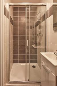 a shower with a glass door next to a sink at Designer Studio in New Town by Prague Days in Prague