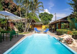 阿拉亞爾達茹達的住宿－Villa Sunset，一个带桌椅的游泳池和一个房子