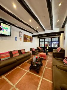 a living room with couches and a flat screen tv at Hatun Inti Classic in Machu Picchu