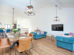 a living room with a table and blue furniture at Primrose-uk34614 in Nether Stowey