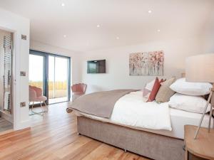 a white bedroom with a bed and a table and chairs at Primrose-uk34614 in Nether Stowey