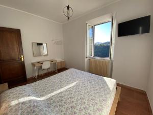 a bedroom with a bed and a desk and a window at Casa Vacanze Nonna Nella in Villafranca in Lunigiana