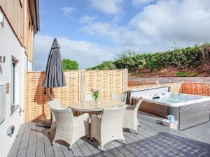 a patio with a table and chairs and a tub at Primrose-uk34614 in Nether Stowey