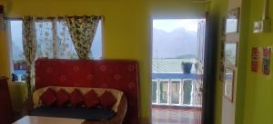 a room with a chair and a large window at Hotel Mon Valley in Tawang