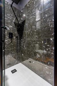 een badkamer met een douche en een zwarte marmeren muur bij [PARENTHESE] - Moissac in Moissac