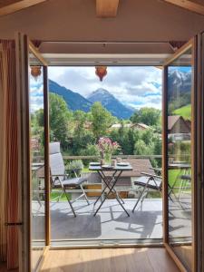 a room with a balcony with a view of the mountains at Sunnefleackle -Haus Lingenhöl in Sonthofen