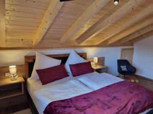 a bedroom with a large bed with red pillows at Sunnefleackle -Haus Lingenhöl in Sonthofen