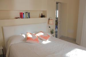 1 dormitorio con 1 cama blanca y 2 almohadas en Case al mare di Cala Saccaia en Pittulongu 