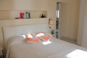 a bedroom with a white bed with two pillows on it at Case al mare di Cala Saccaia in Pittulongu
