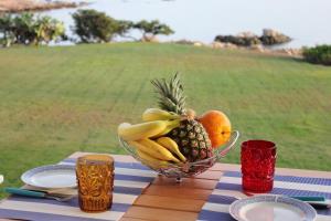 uma taça de fruta em cima de uma mesa em Case al mare di Cala Saccaia em Pittulongu 