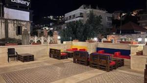 un patio con sedie e tavoli colorati su un edificio di La Place Hotel a Zahlé