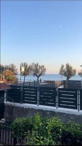 una valla negra con árboles y el océano en el fondo en [Casa sul mare]+Posto auto+Giardino+WiFi, en Terracina