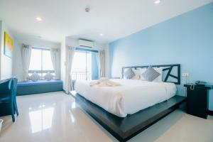 a bedroom with a large white bed with blue walls at Sleep Whale Hotel in Krabi