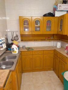 a kitchen with wooden cabinets and a sink at Zekry nubian guest house in Aswan
