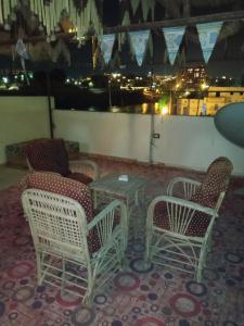 a group of chairs and a table on a balcony at Zekry nubian guest house in Aswan