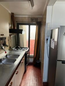 a kitchen with a sink and a refrigerator at Casa Bonita Barrio Sur in Santa Fe +2 photos