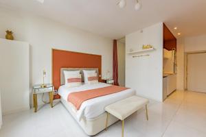 een slaapkamer met een groot bed met een oranje hoofdeinde bij [PARENTHESE] - Moissac in Moissac