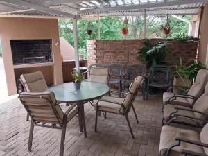 a patio with a table and chairs and a brick wall at Lily Guesthouse in Bloemfontein +24 photos