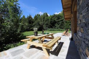 drewniany stół piknikowy na kamiennym patio w obiekcie Chalet de l’Alpette w mieście Valloire