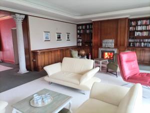 een woonkamer met witte meubels en een open haard bij Villa mit Auffahrt in Bad Pyrmont